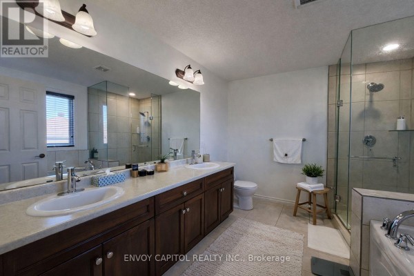Modern bathroom with double vanity, glass shower, and tile floor - 402 Palamino Place, Waterloo