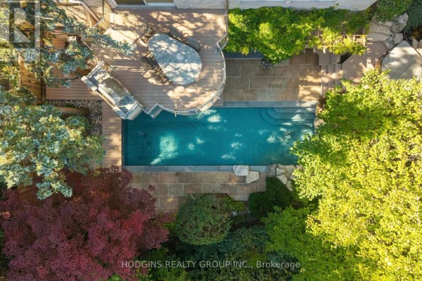 Overhead view of a backyard featuring a rectangular swimming pool, stone patio, and outdoor dining area. - 4028 Powderhorn Court, Mississauga