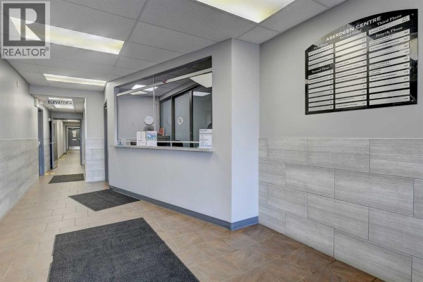 Reception area with a counter, glass partition, and directory board on the wall. - 403, 9728 101 Avenue, Grande Prairie