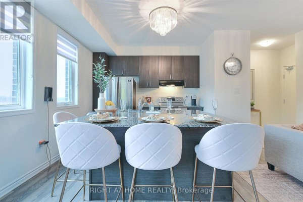 Kitchen island with three white upholstered bar stools and granite countertop, facing dark wood cabinets. - 403 - 1148 Dragonfly Ave Avenue, Pickering