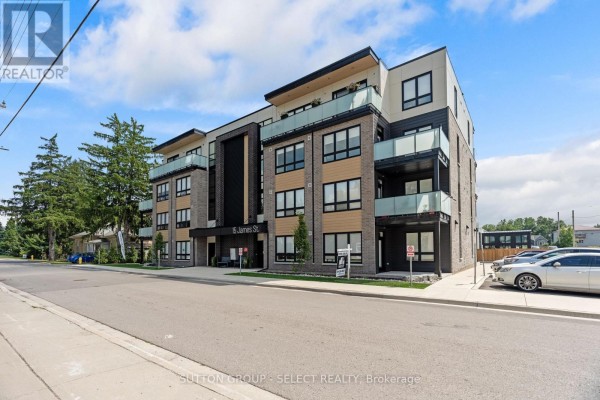 Exterior view of a multi-story apartment building with balconies and glass railings. - 403 - 15 James Street, South Huron