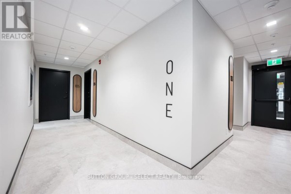 Interior hallway of an apartment building with white walls, black doors, and numbered apartment entrances. - 403 - 15 James Street, South Huron