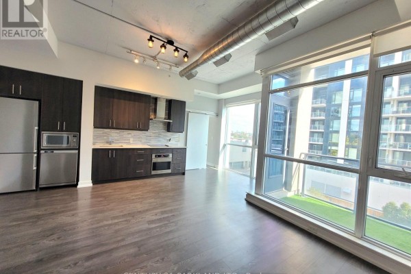 View of the living space, kitchen, and balcony with large windows and city views. - 403 - 75 The Donway W, Toronto