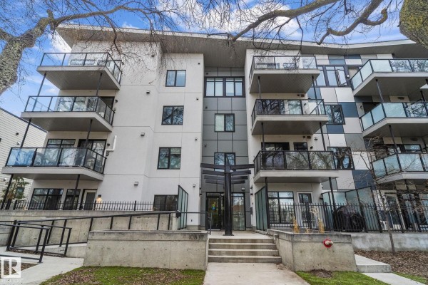 Close-up of apartment building entrance with glass doors and concrete stairs. - #403 10837 83 Av Nw Nw, Edmonton