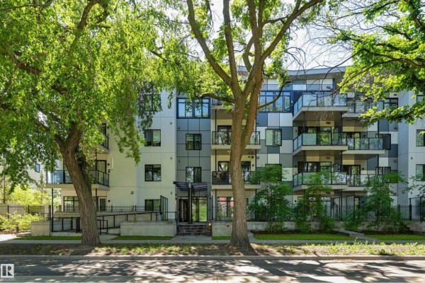 Apartment building with white, grey, and glass facade, surrounded by trees. - #403 10837 83 Av Nw Nw, Edmonton
