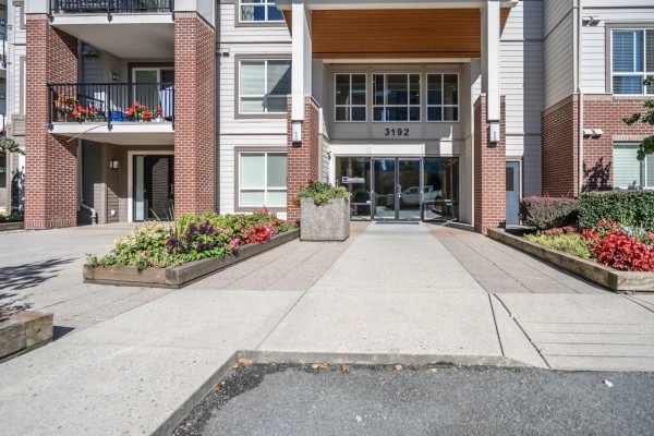 Entrance to apartment building 3192 Gladwin Road with planters and paved walkway. - 403 3192 Gladwin Road, Abbotsford