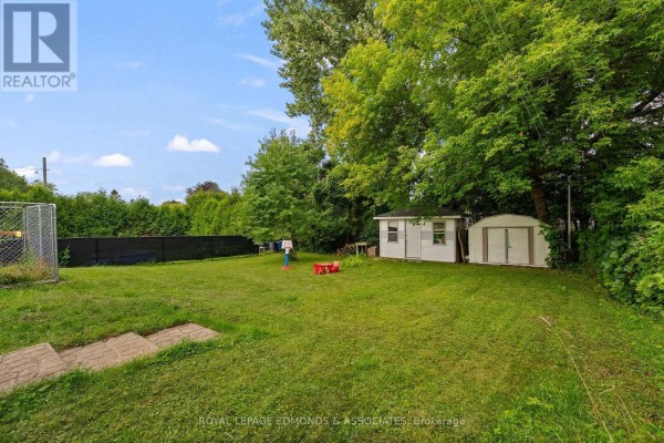 Backyard with sheds, dog kennel, basketball hoop, and child's table - 403 Alfred Street Pembroke