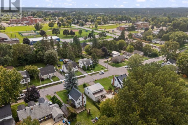Aerial view of a residential neighborhood with houses, streets, trees, and a sports field in the distance. - 403 Alfred Street, Pembroke