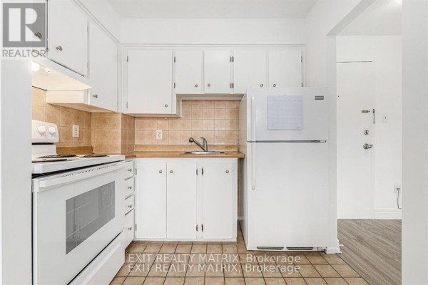 White kitchen with white cabinets, beige tiled backsplash, white stove, and refrigerator. - 403c - 2041 Arrowsmith Drive, Ottawa