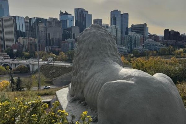 Stone lion statue facing the Calgary skyline with a bridge and highway. - 404, 222 5 Avenue Ne, Calgary