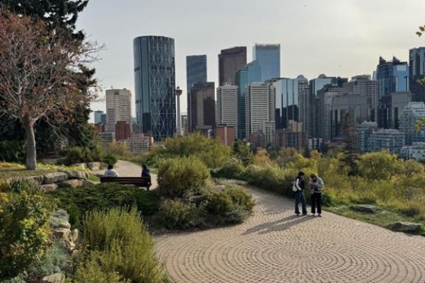 People walking on a paved path in a park with the Calgary skyline behind. - 404, 222 5 Avenue Ne, Calgary