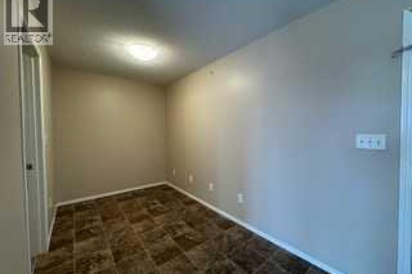 Small room with beige walls, tiled floor, and a white door. - 404, 7130 80 Avenue Ne, Calgary