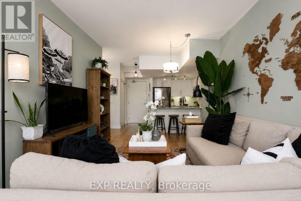 Hallway view of bedroom with king bed and framed tiger artwork on wall. - 404 - 500 St Clair Avenue W, Toronto