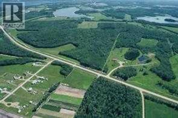 Overhead view of a large green field with a dense forest bordering it. - 404-13352 Lakeland, Rural Lac La Biche County