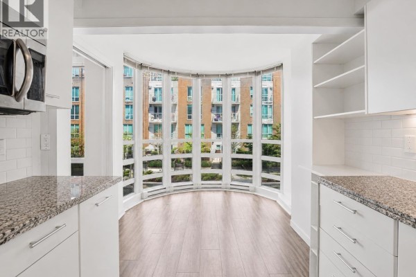 Exterior of brick townhouses with balconies and a decorative water feature in front. - 404 1501 Howe Street, Vancouver