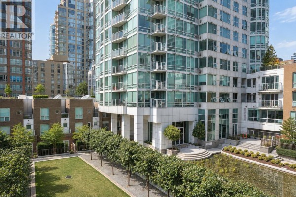 A manicured green lawn with rows of trees and modern apartment buildings in background. - 404 1501 Howe Street, Vancouver