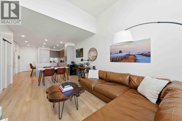 Open concept living and dining area with a sectional sofa and kitchen view. - 414 1892 Starling Drive, Tsawwassen