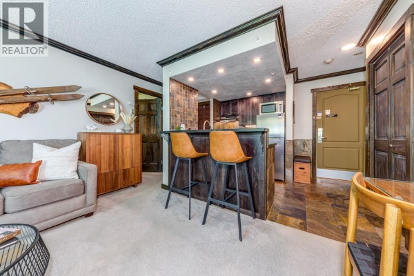 Exterior view of The Marquise building with a stone and wood entrance. - 404 4809 Spearhead Drive, Whistler