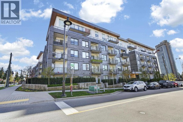 Building lobby with wood-paneled walls, tiled floor, mailboxes, and a bench with artwork. - 404 648 Lea Avenue, Coquitlam