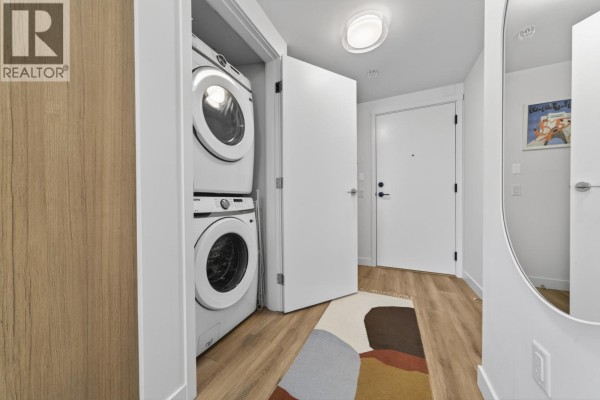 Apartment interior hallway looking towards living area, with white doors, wood-look floor, and a mirror. - 404 648 Lea Avenue, Coquitlam