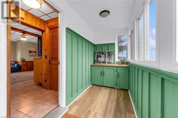 Interior entryway with green paneled walls, wood cabinets, and tile floor. - 404 Concession 5 Road, Fisherville
