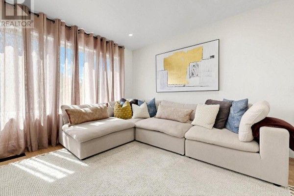 Living room with a large sectional sofa, textured rug, and floor-to-ceiling windows. - 404 Glen Park Avenue, Toronto