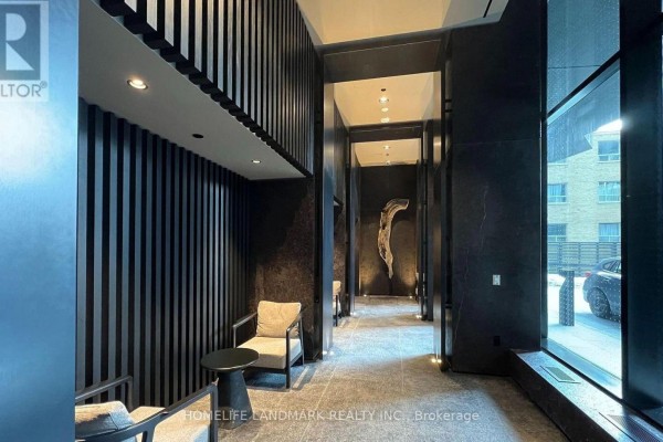 Apartment building lobby seating area with two chairs, a small table, and dark wood paneling. - 404 S - 110 Broadway Avenue, Toronto