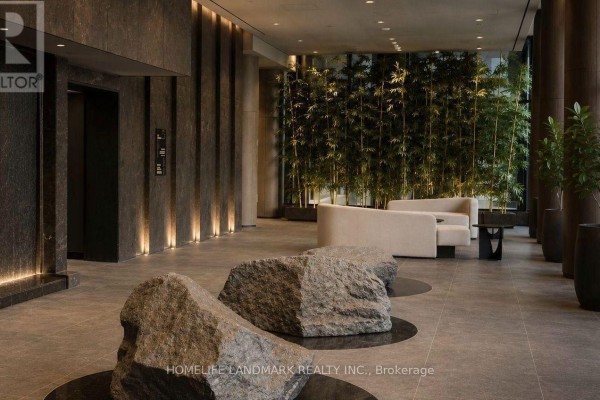 Building lobby with natural stone accents, large boulder seating, and a bamboo plant wall. - 404 S - 110 Broadway Avenue, Toronto
