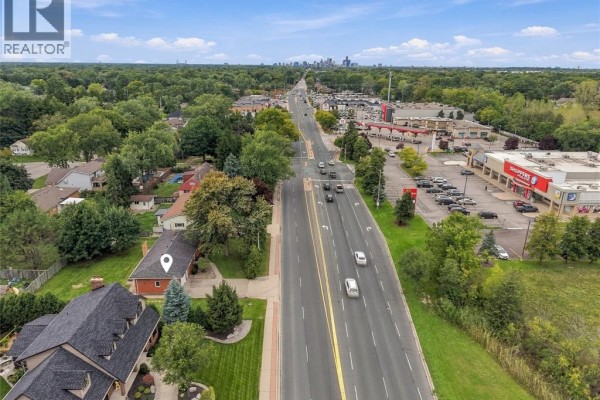 Aerial view of house on Dougall Avenue with view of commercial buildings and distant city skyline. - 4045 Dougall Avenue, Windsor