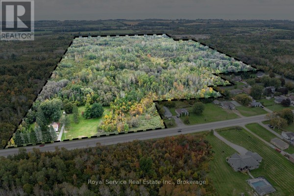 Aerial view of a large wooded property with a house and surrounding homes. - 4045 Highway 2, Clarington