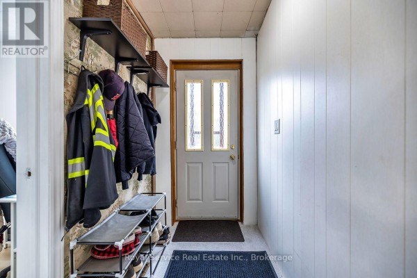 Interior entryway with a white door, shoe rack, and coats hanging. - 4045 Highway 2, Clarington