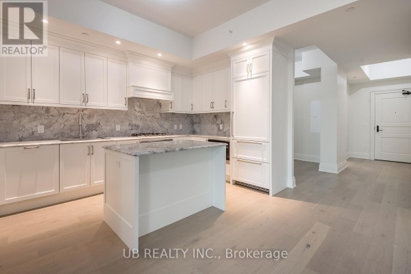 Kitchen with white cabinets, marble countertops and backsplash, and a view towards the living area. - 405 - 1451 Wellington Street W, Ottawa