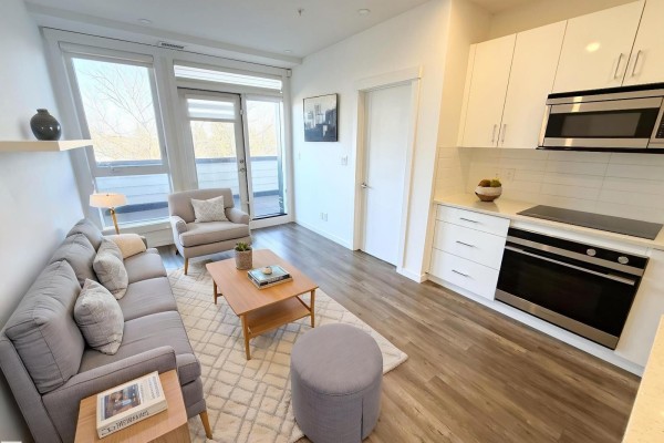 Bright bedroom with large window and access to a private balcony, featuring light wood flooring. - #405 11503 76 Av Nw, Edmonton