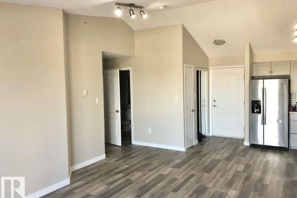Empty closet with beige walls and a single wire shelf. - #405 151 Edwards Dr Sw, Edmonton