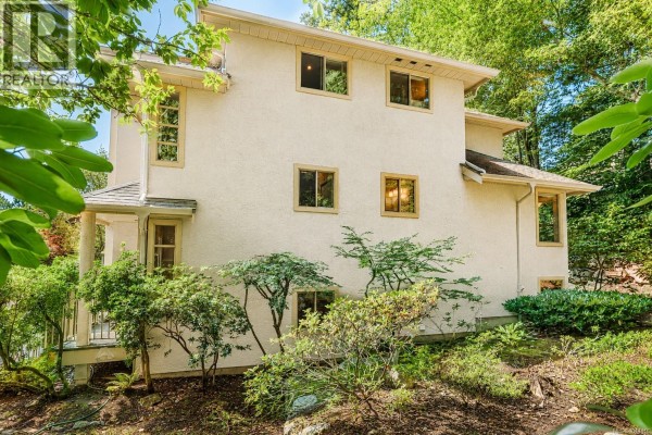 Side exterior view of the townhouse with multiple windows and surrounding greenery. - 405 510 Marsett Pl, Saanich