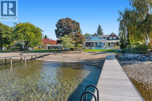 Waterfront property with wooden dock, pebble beach, and a view of the lake and surrounding hills. - 405 Hobson Crescent, Kelowna