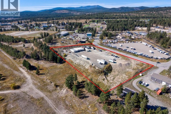 Drone shot of a spacious industrial property with gravel ground, outlined in red, surrounded by trees. - 405 Industrial F Road, Cranbrook