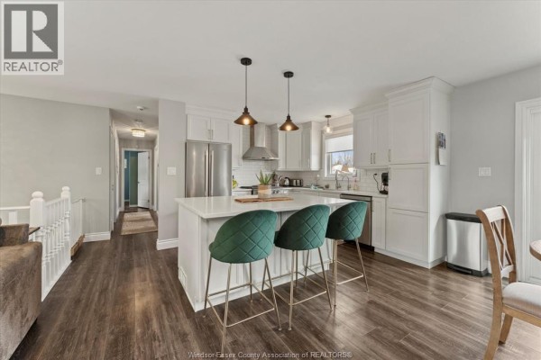 Modern kitchen with white cabinetry, island, and green bar stools - 405 State Street, Lasalle