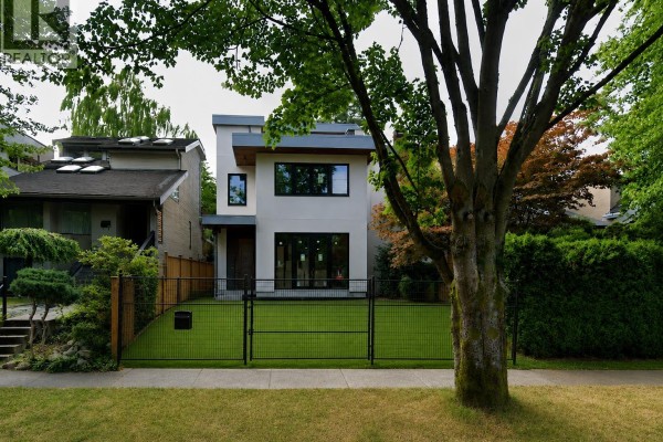 Front exterior of a contemporary home with dark metal fence and green lawn. - 4054 W 17th Avenue, Vancouver