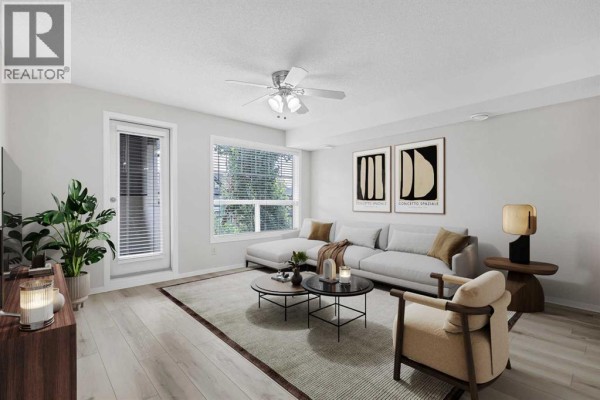 Furnished living room with sectional sofa, coffee table, chairs, and large window. - 406, 140 Sagewood Boulevard Sw, Airdrie
