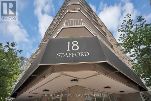 Close-up exterior view of the apartment building entrance with "18 STAFFORD" signage. - 406 - 18 Stafford Street, Toronto