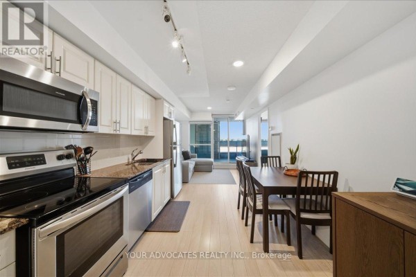 View of kitchen, dining area, and living room with large window and balcony. - 406 - 3091 Dufferin Street, Toronto