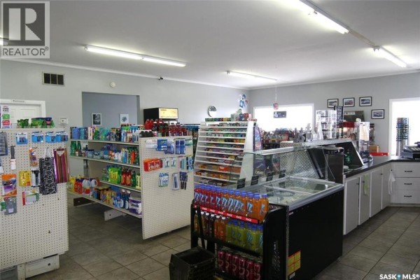 Front view of a convenience store with a covered porch and outdoor seating. - 406 - 410 Railway Avenue, Eston