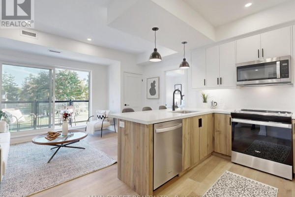 Open-concept kitchen and living area with a large island and patio doors. - 406 - 49 Charles Street, Newmarket