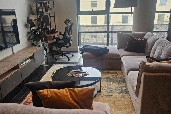 Living room with sectional sofa, coffee table, and large windows overlooking the city. - 406 - 90 Sumach Street, Toronto
