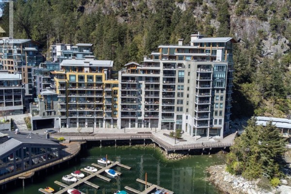 Wide aerial view of a large marina filled with boats, adjacent to a waterfront apartment complex. - 406 6707 Nelson Avenue, West Vancouver