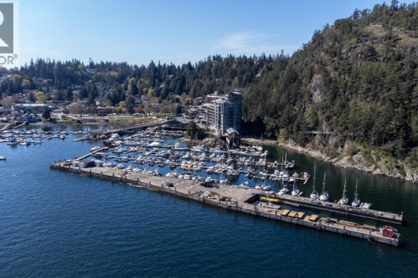 Aerial view of the apartment complex, marina, and inlet with snow-capped mountains and a ferry in the distance. - 406 6707 Nelson Avenue, West Vancouver