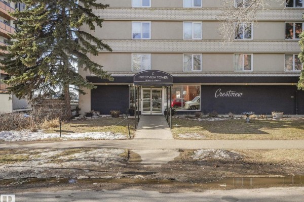 Exterior view of Crestview Tower apartment building entrance with a glass door and canopy. - #406 9816 112 St Nw, Edmonton