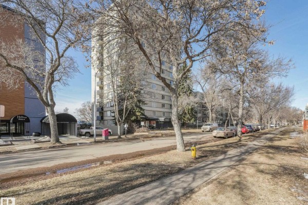 Street view of Crestview Tower apartment building and surrounding trees on a sunny day. - #406 9816 112 St Nw, Edmonton