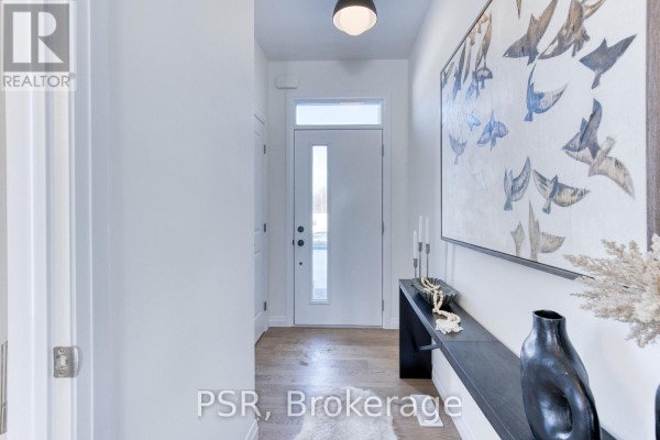 Entrance hallway with white walls, a front door with glass panels, and large abstract artwork on the wall. - 406 Green Gate Boulevard, Cambridge